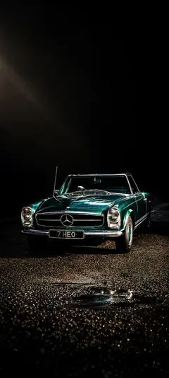 Klassischer Mercedes Oldtimer Roadster bei Nacht auf nasser Straße mit dramatischem Licht als vertikales Handy Wallpaper
