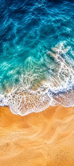 Sommer Strand Hintergrundbild mit türkisblauem Wasser, Meereswellen und goldenem Sand als Handy Wallpaper.