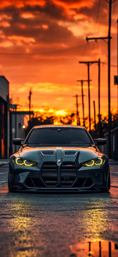 Dunkelgrauer BMW M4 G82 mit gelben Tagfahrleuchten auf nasser Straße bei Sonnenuntergang – Hochauflösendes Hintergrundbild.