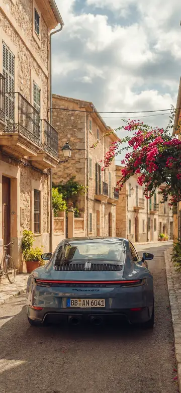 4K Handy Hintergrundbild eines blaugrauen Porsche 911 Carrera GTS in einem mediterranen Dorf.