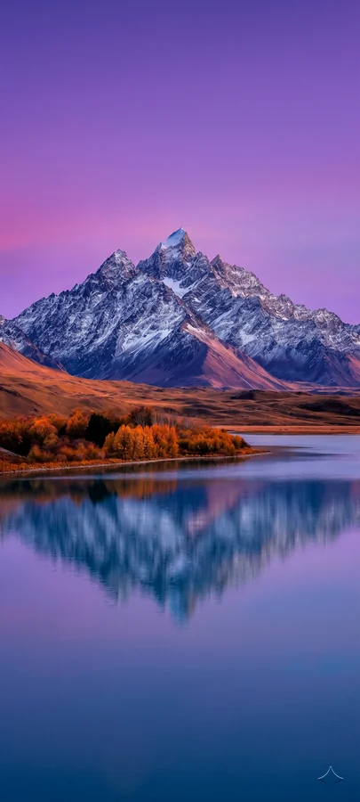 Schneebedeckter Berg mit Spiegelung im ruhigen See unter violettem Himmel in ästhetischer hintergrundbilder Naturkulisse in 4K.